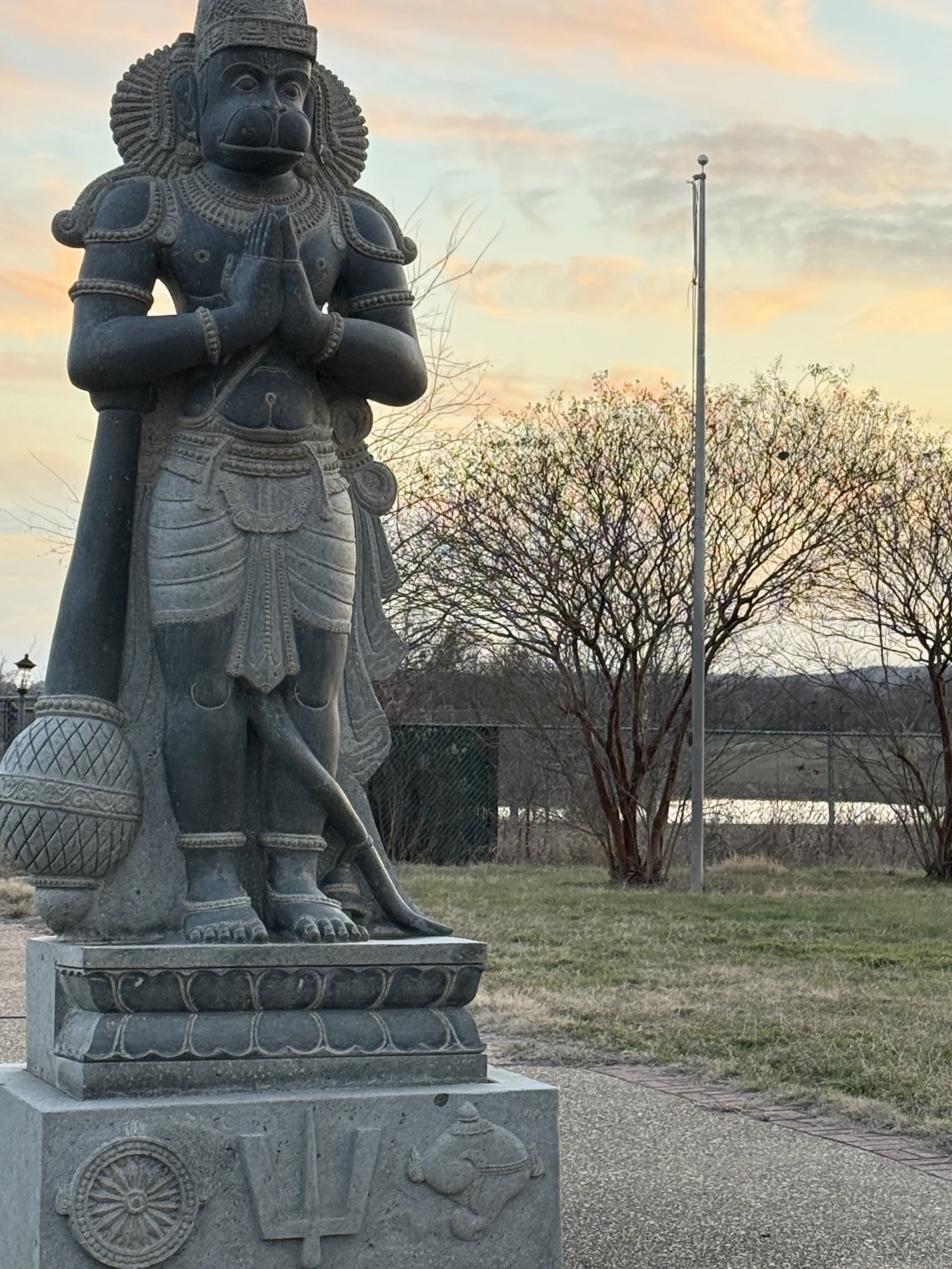 Lord Hanuman murti on the temple grounds at dusk — shown in full